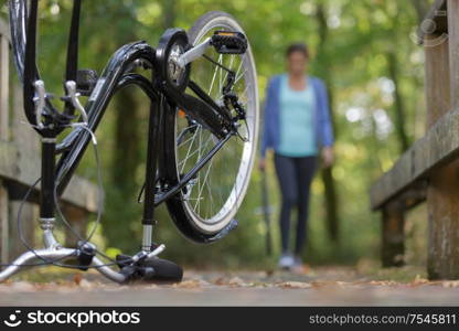 woman returning to her upended bicycle