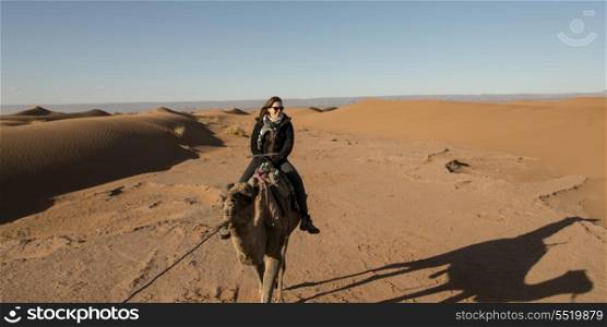 Woman riding a camel in Erg Chegaga Dunes, Sahara Desert, Souss-Massa-Draa, Morocco