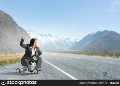 Woman riding bicycle. Young pretty businesswoman riding three wheeled bike