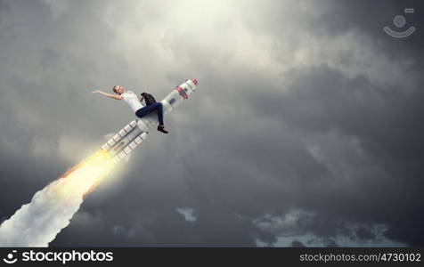 Woman riding missile. Young businesswoman flying in sky on space rocket