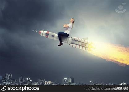 Woman riding missile. Young businesswoman flying in sky on space rocket