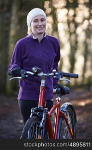 Woman Riding Mountain Bike Through Woodlands