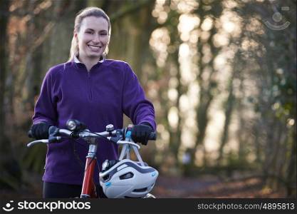 Woman Riding Mountain Bike Through Woodlands