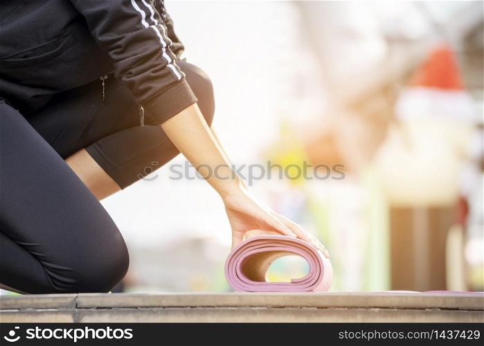 Woman roll yoga mat fitness workout people close up on hands when rolling mat. Healthy woman practice meditating concentration. Banner with copy space. Healthy fitness woman lifestyle concept.