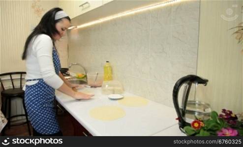 Woman Rolling Dough On Counter Top