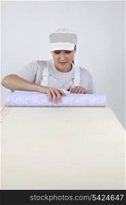 Woman rolling out wallpaper