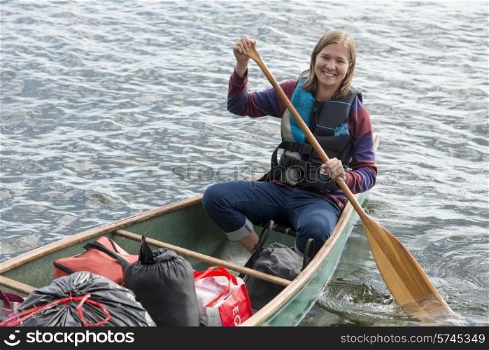 Woman rowing a boat in a lake, Lake of The Woods, Ontario, Canada