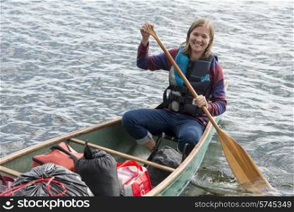 Woman rowing a boat in a lake, Lake of The Woods, Ontario, Canada
