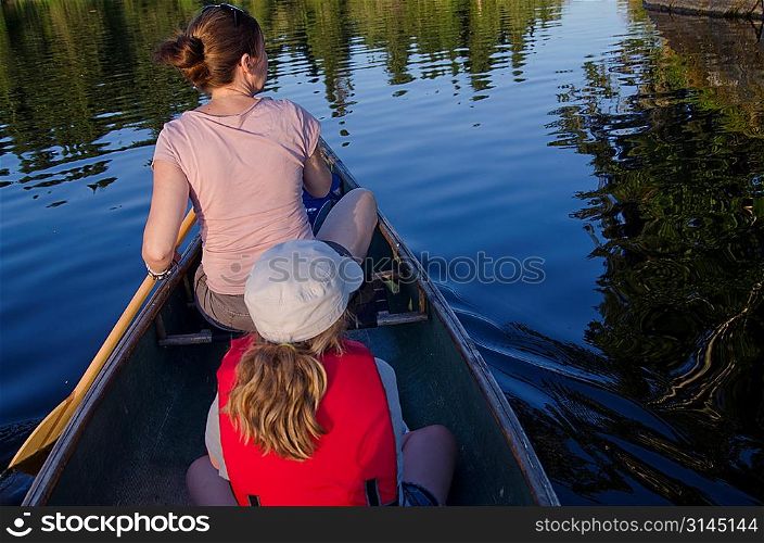 Woman rowing a boat with her daughter, Lake of the Woods, Ontario, Canada