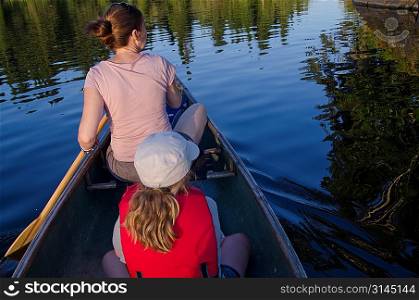 Woman rowing a boat with her daughter, Lake of the Woods, Ontario, Canada