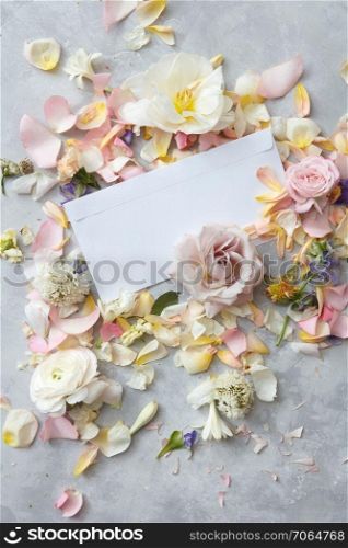 Woman&rsquo;s Day concept. Copy space may be used for writing your ideas, emotions. Composition of flowers decorating white blank copy space over grey background.. Composition of flowers on grey background
