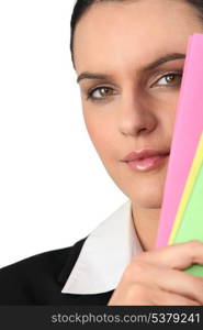 Woman&rsquo;s face behind folders