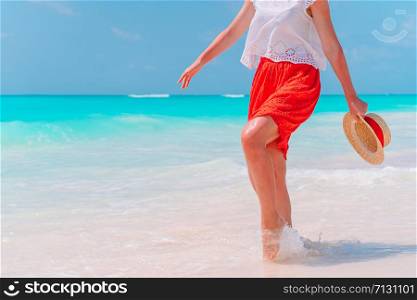 Woman&rsquo;s feet on the white sand beach in shallow water. Close up of female feet on white sand beach