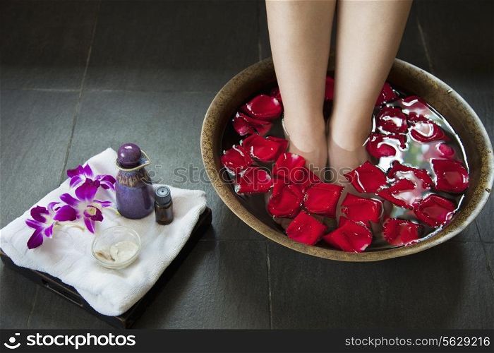 Woman&rsquo;s Feet Soaking in Water with Rose Petals