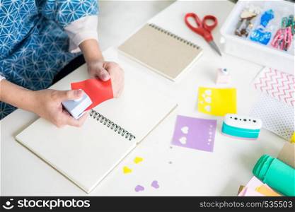 Woman's hand cut paper Making a scrap booking or other festive decorations DIY accessories arrangement