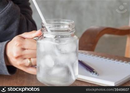 Woman&rsquo;s hand holding a cold glass of water, stock photo