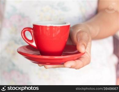 Woman&rsquo;s hand holding red coffee cup, stock photo