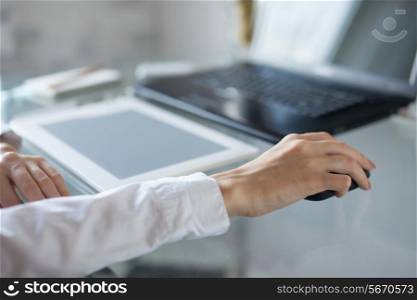 Woman&rsquo;s hand using cordless mouse on glass table