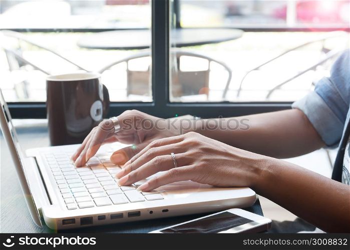 Woman&rsquo;s hand using laptop computer and mobile device in cafe, Online shopping and Technology concept