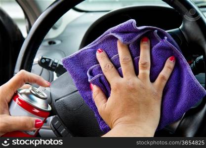 Woman&rsquo;s hand with microfiber cloth polishing wheel of a car