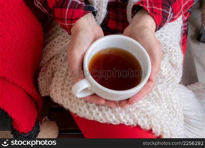 Woman&rsquo;s hands are holding white cup of tea or coffee dressed in red and white festive clothes.. woman female holdingcup tea coffee red festive clothes christmas new year valentine