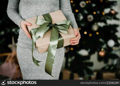 Woman&rsquo;s hands hold christmas present or new year decorated gift box. Toned picture. Merry Christmas and Happy Holidays. Close up.