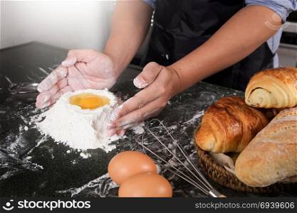 Woman&rsquo;s hands knead dough with flour, eggs and ingredients. at kitchen