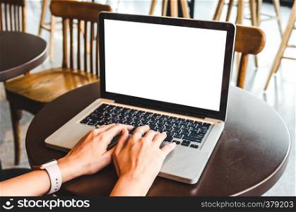 Woman's hands using computer laptop with blank screen on desk.