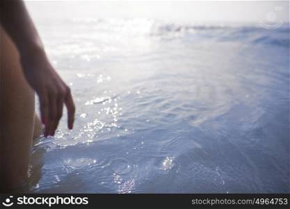 Woman&rsquo;s legs and hand standing looking at ocean