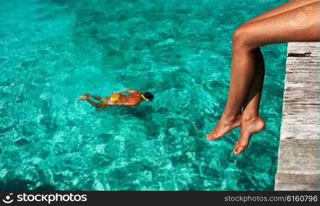 Woman&rsquo;s legs at beach jetty