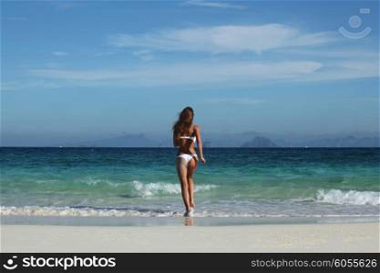 Woman run into sea. Beautiful fit woman in bikni run into tropical sea