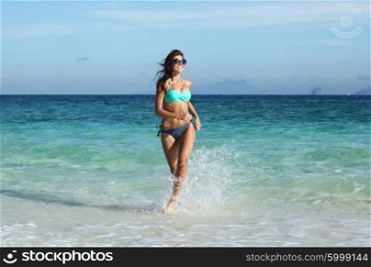Woman run on beach. Beautiful fit woman in bikni run on tropical beach