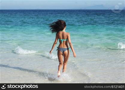 Woman run to sea. Beautiful fit woman in bikni run to tropical sea