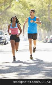 Woman Running Along Street With Personal Trainer