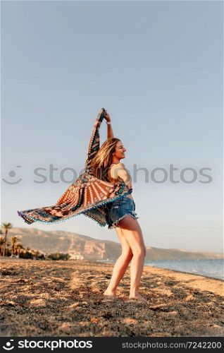 Woman running and holding scarf on wave relax and happy on beach
