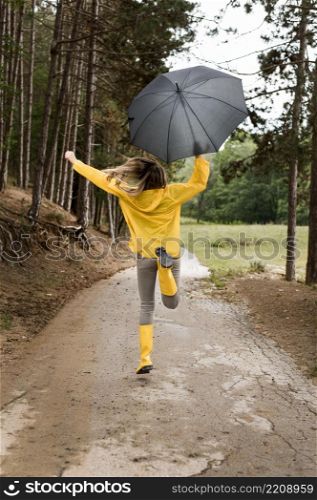 woman running forest while holding umbrella