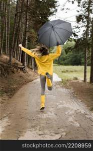 woman running forest while holding umbrella