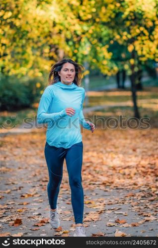Woman Running in Public Park in the Fall.