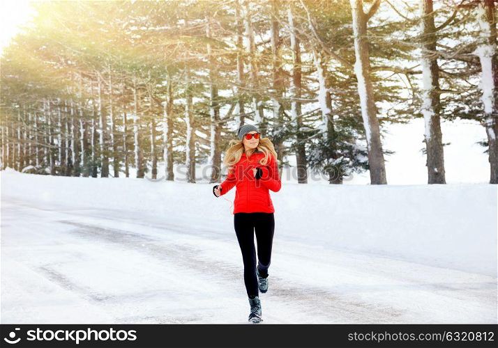 Woman running in the winter park, doing exercise in cold frosty morning, workout outdoors, healthy lifestyle, wintertime sport
