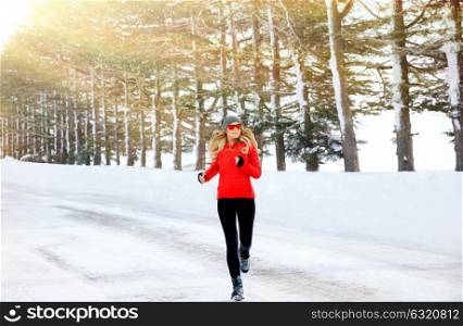 Woman running in the winter park, doing exercise in cold frosty morning, workout outdoors, healthy lifestyle, wintertime sport