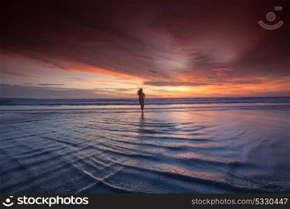 Woman running on beach at sunset. Woman in bikini running on the beach at sunset. Bali island, Indonesia