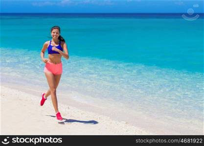 Woman running on beach. Beautiful young fitness woman running on beach