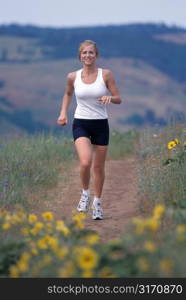 Woman Running on Dusty Trail Through Meadow