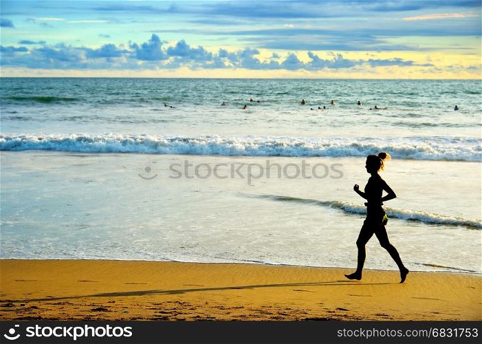 Woman running on the beach at sunset. Bali island, Indonesia