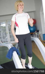 Woman Running On Treadmill At Gym