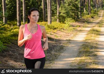 Woman running through forest outdoor training on sunny day