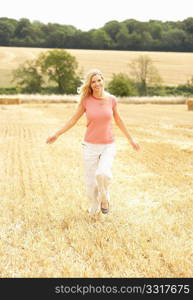 Woman Running Through Summer Harvested Field