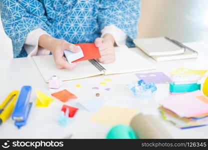 Woman’s hand cut paper Making a scrap booking or other festive decorations DIY accessories arrangement