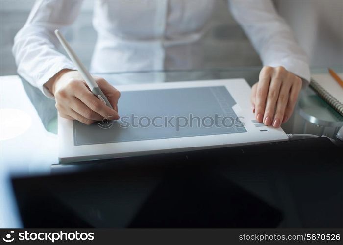 Woman`s hand drawing with a graphics pad and notebook