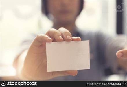woman's hand holding blank white name card, selective focus and vintage tone
